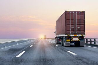 Ein LKW fährt in den Sonnenuntergang