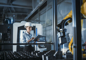 Eine Frau inspiziert eine Industriemaschine