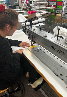 Waldo in der Produktion an der Nähmaschine